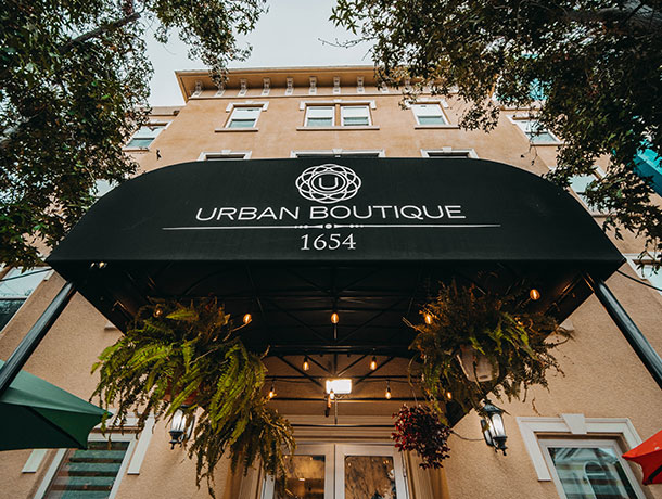 A black awning with white text reading 'URBAN BOUTIQUE' and '1654' above a building entrance.