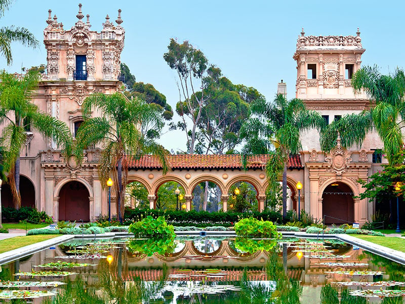 A large building with a courtyard and a pond in front of it.