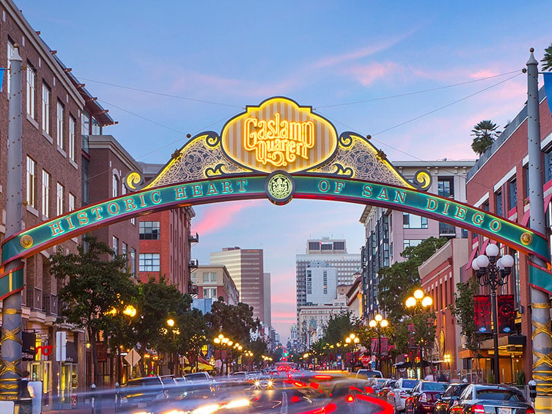 A colorful archway over a city street with cars and buildings.
